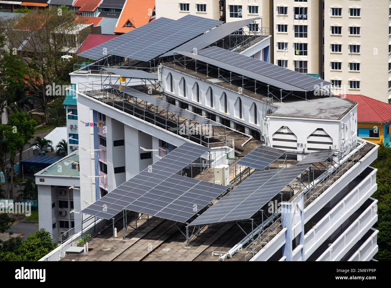 Solar panels installed on public housing roof top to harvest energy from the tropical weather climate in Singapore. Stock Photo