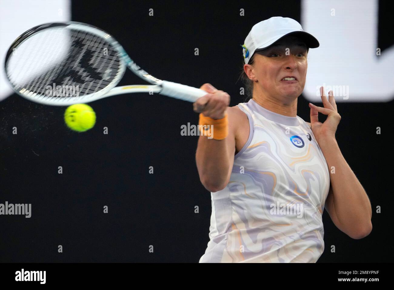 Iga Swiatek of Poland plays a forehand return to Jule Niemeier of Germany during their first round match at the Australian Open tennis championship in Melbourne, Australia, Monday, Jan