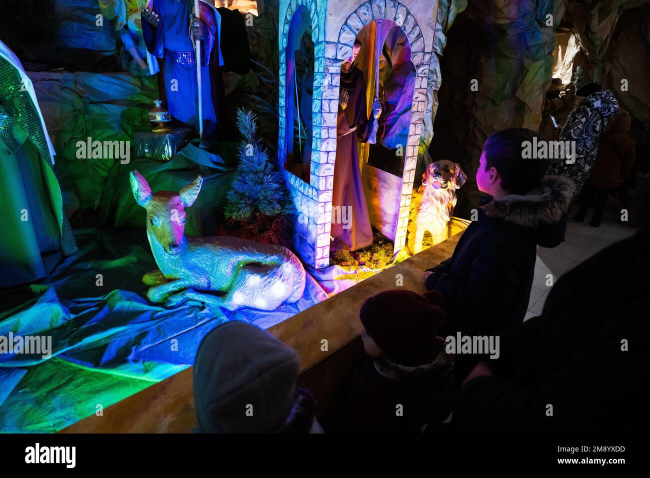 Three children looking in Christmas nativity crib scene in church Stock ...