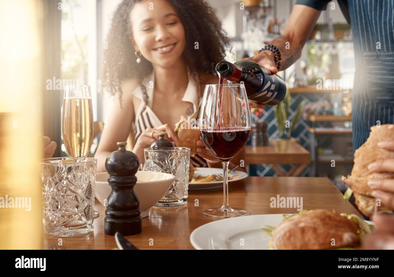 They carry the best wines. a young woman having a glass of wine poured