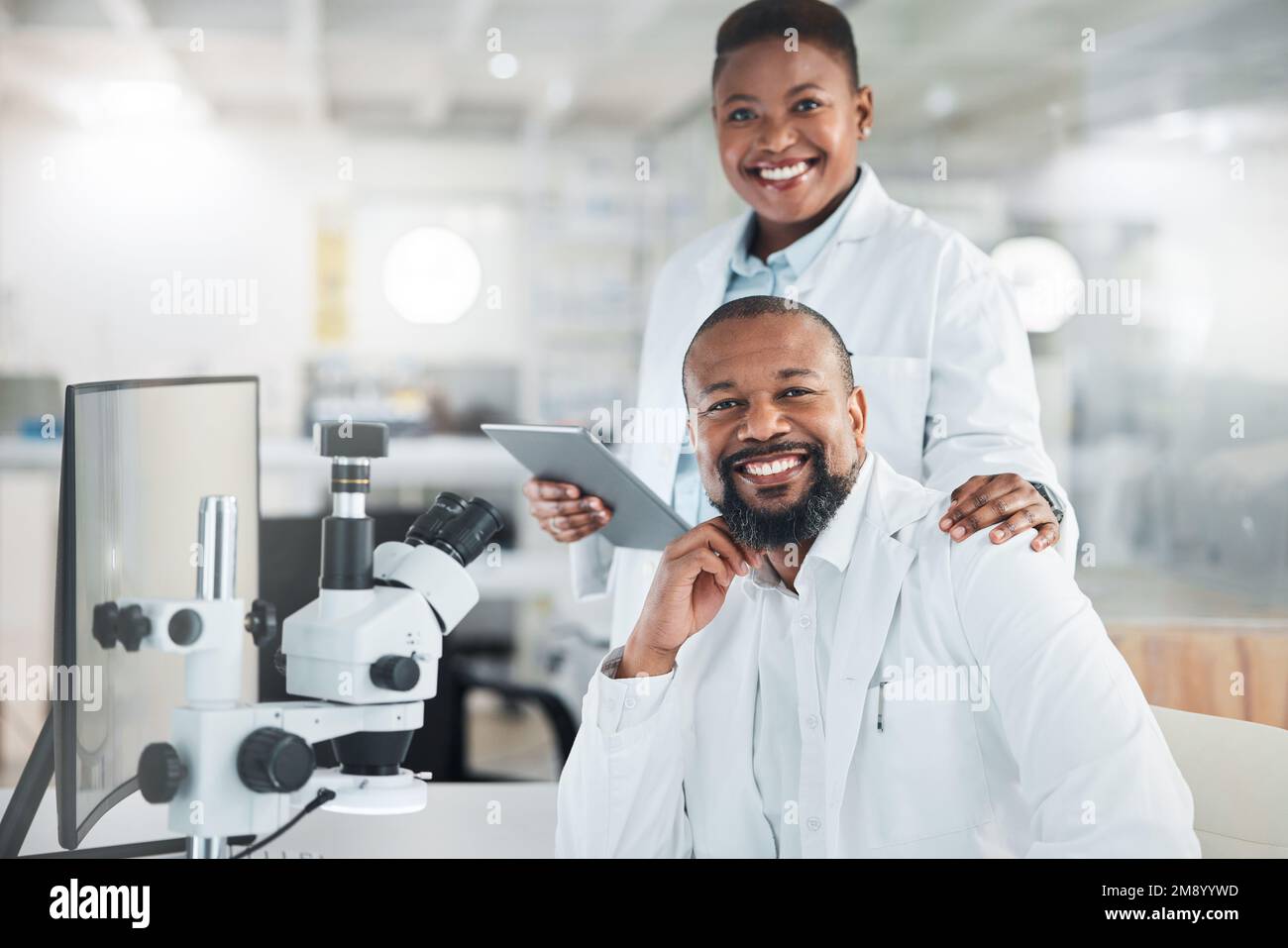 You have to be very precise when working with samples. two scientists using microscopes in a lab. Stock Photo