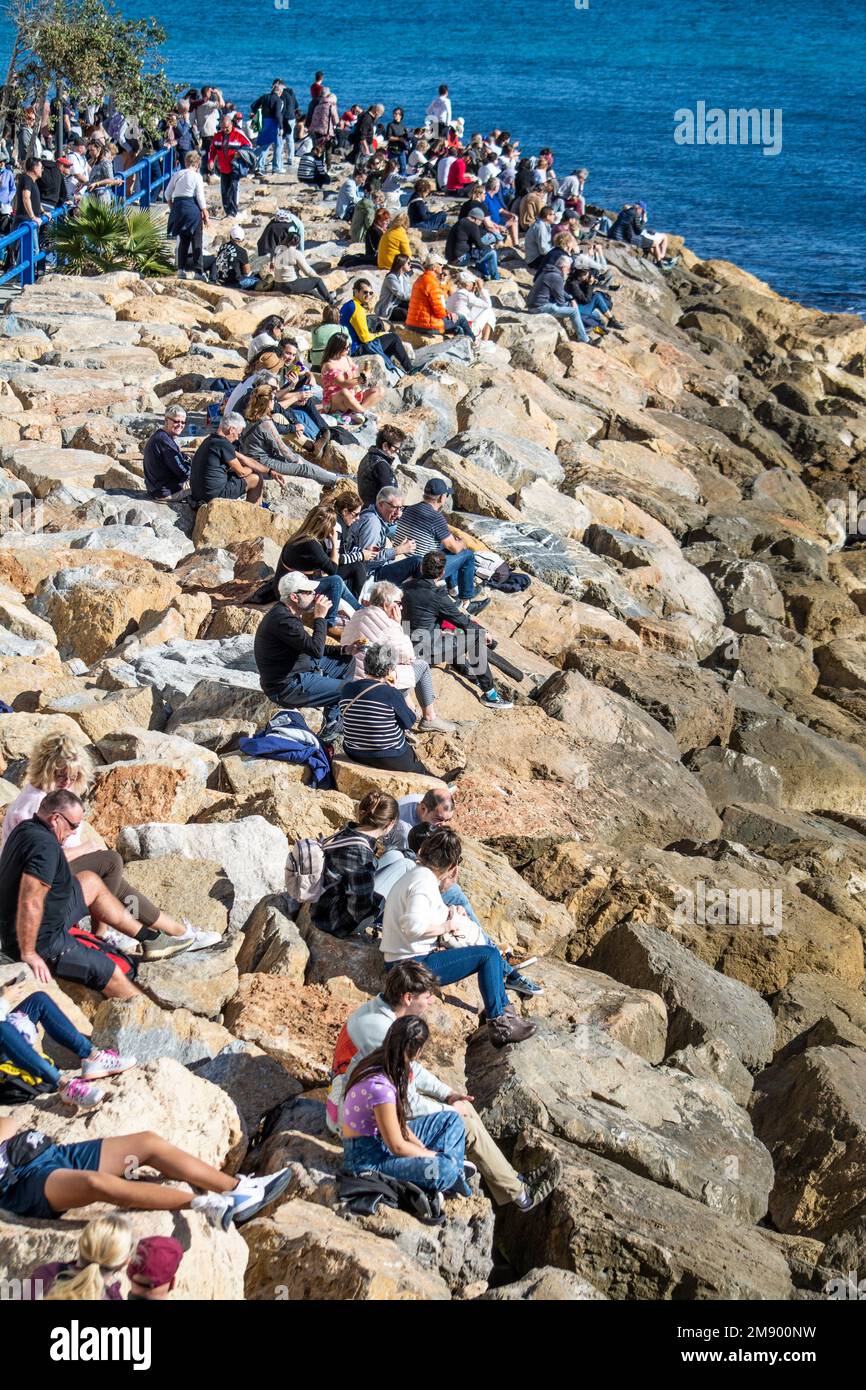 Spectators sitting on rocks waiting for the Ocean Race to begin. Stock Photo
