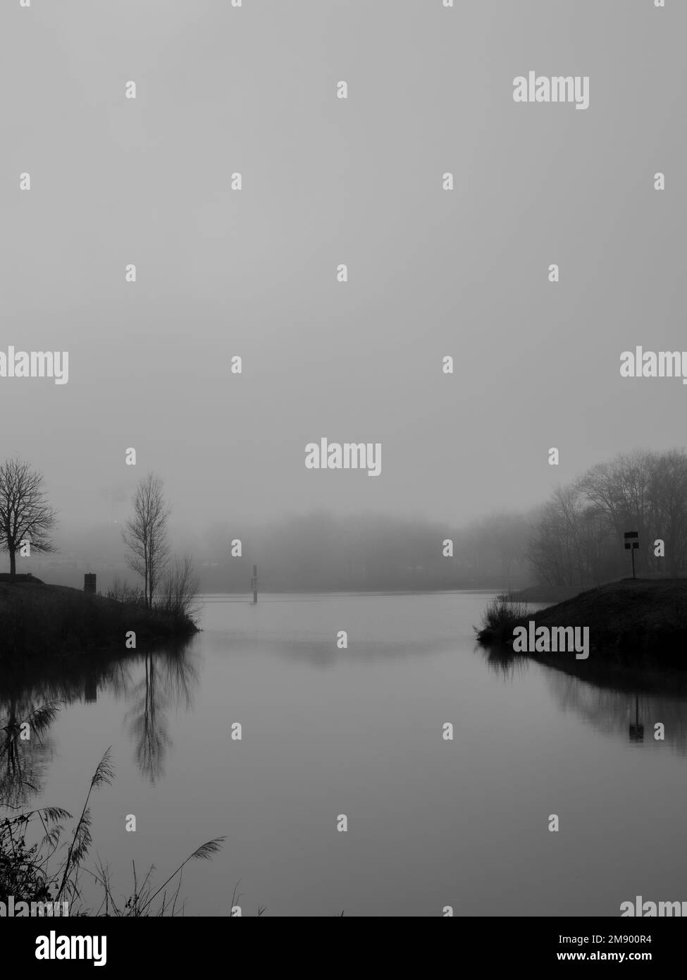 Winter river landscape with fog and silhouette of trees in the background. black and white photo Stock Photo