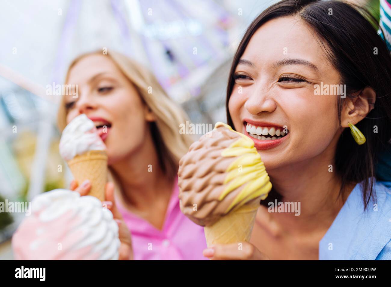 Multiracial young people together meeting at amusement park and eating