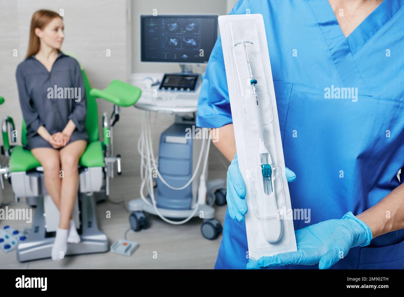 doctor gynecologist offers female patient to use IUD to prevent pregnancy. Intrauterine contraceptive device or coil Stock Photo