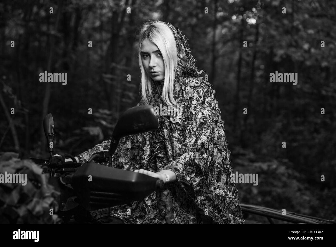 A grayscale of a blonde Caucasian white woman in camouflage clothing in