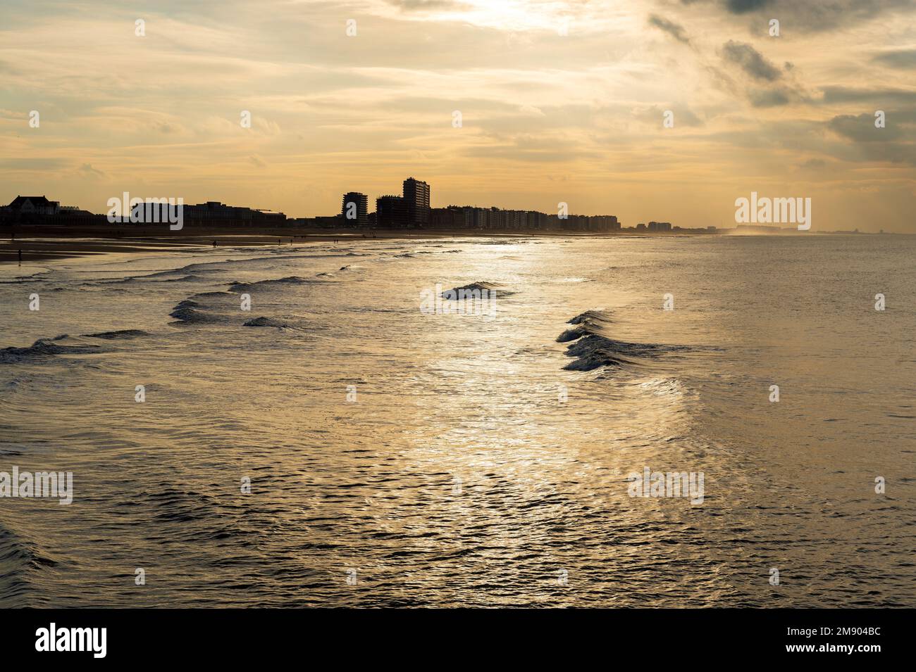 North Sea waves at sunset with Oostende (Ostend) beach and skyline, West Flanders, Belgium. Stock Photo