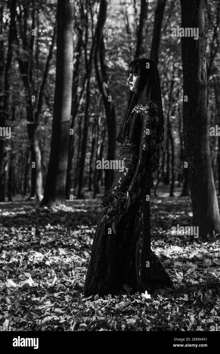 A vertical grayscale of a scary corpse bride in the autumn forest Stock Photo