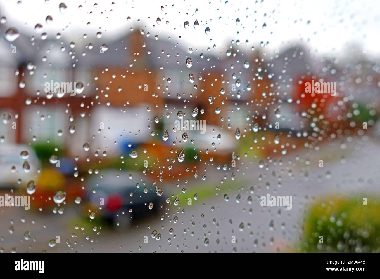 Water drops, on a window, with out of focus street - Another dull rainy day with no urge to leave the home Stock Photo