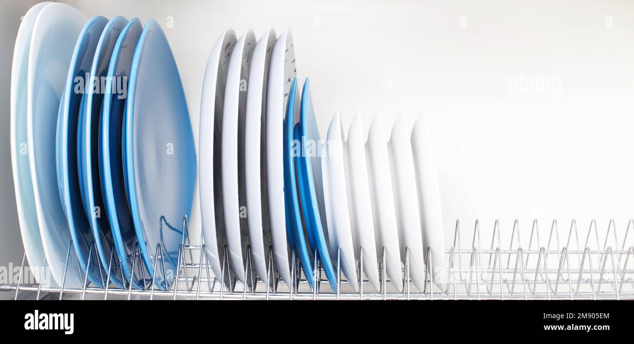 clean dishes stand in a drawer for drying dishes in the kitchen Stock