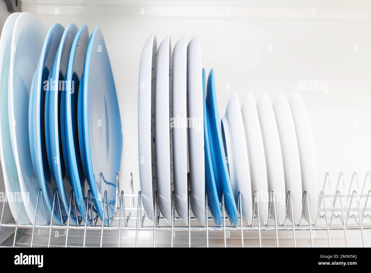 clean dishes stand in a drawer for drying dishes in the kitchen Stock
