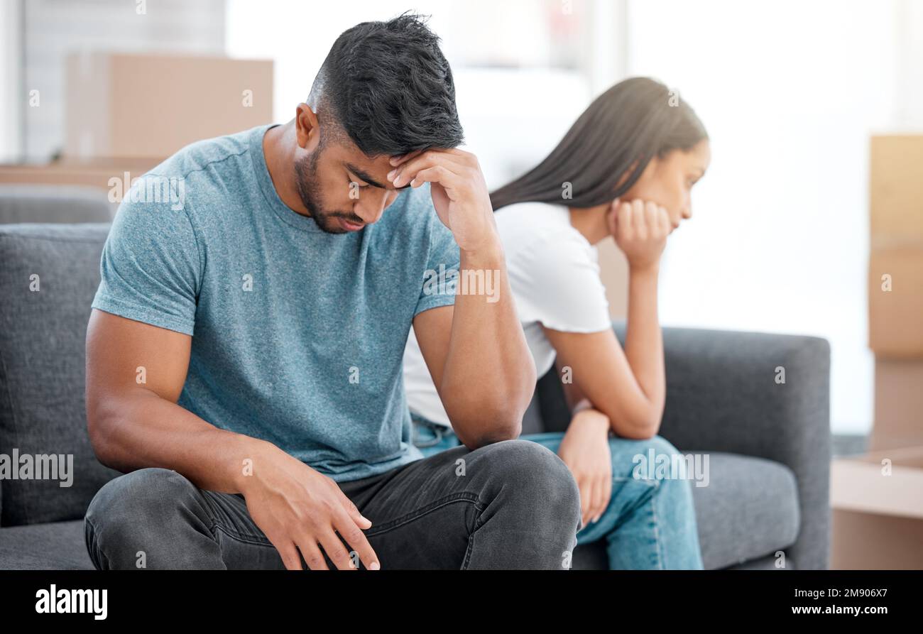These fights are happening too often. a young couple sitting on the sofa at home and ignoring