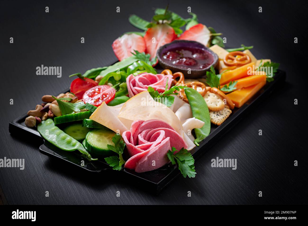 Antipasto platter cold sliced ham, salami, crackers, strawberries