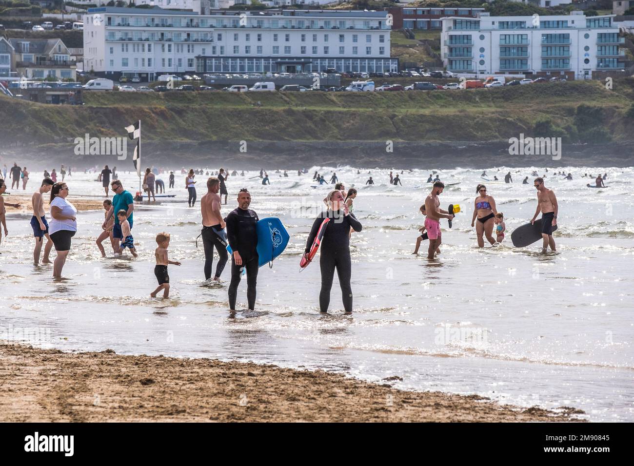 Holidaymakers cooling off in the sea at a busy Fistral Beach Newquay in Cornwall in the UK. Stock Photo