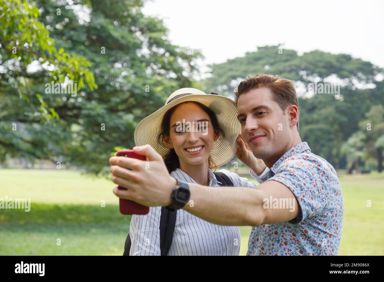 happy young smiling couple selfie with smart phone in summer travel on vacation. man and woman couple lover taking self portrait with outdoor nature p Stock Photo