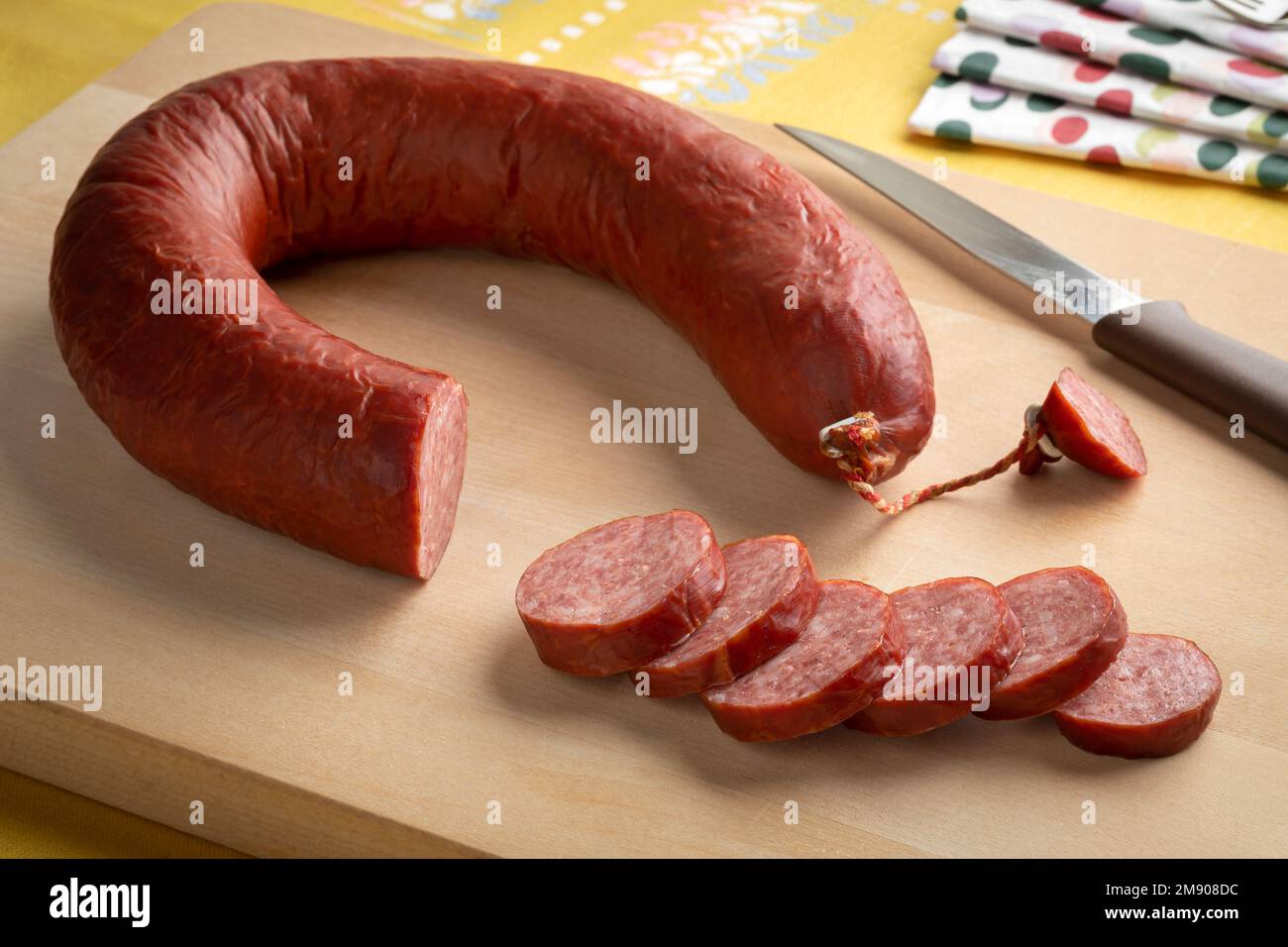 Traditional Dutch smoked horsemeat sausage and slices on a cuttingboard close up Stock Photo