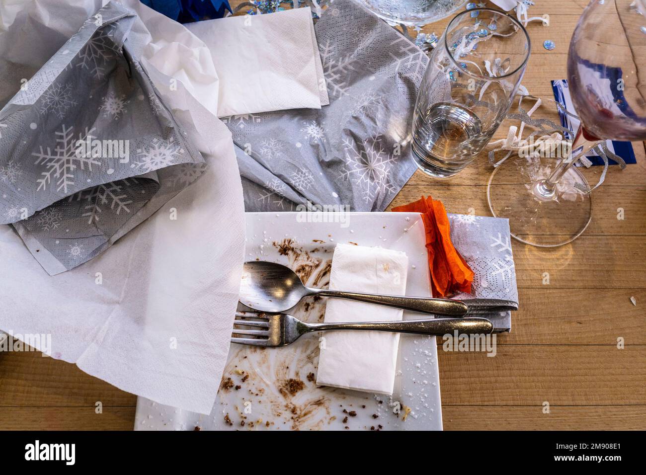 An overhead view of used dishes and glasses on a table after a Christmas meal in a restaurant. Stock Photo