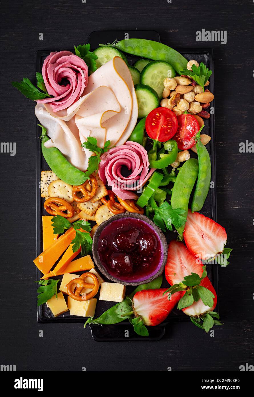 Antipasto platter cold sliced ham, salami, crackers, strawberries