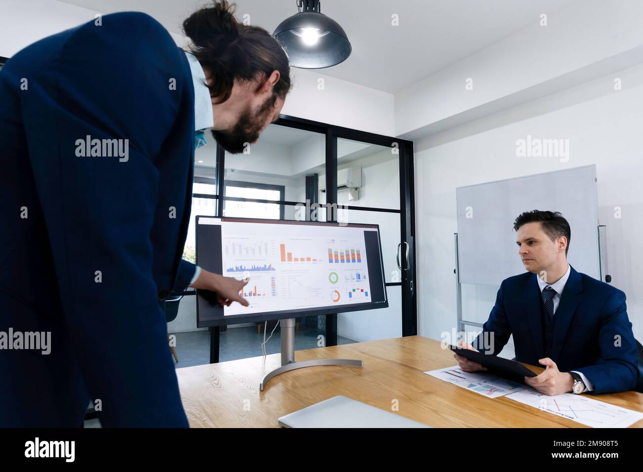 Two young investor businessmen meeting to analysis risk and profit opportunity investment in international stock market. Business finance and banking Stock Photo
