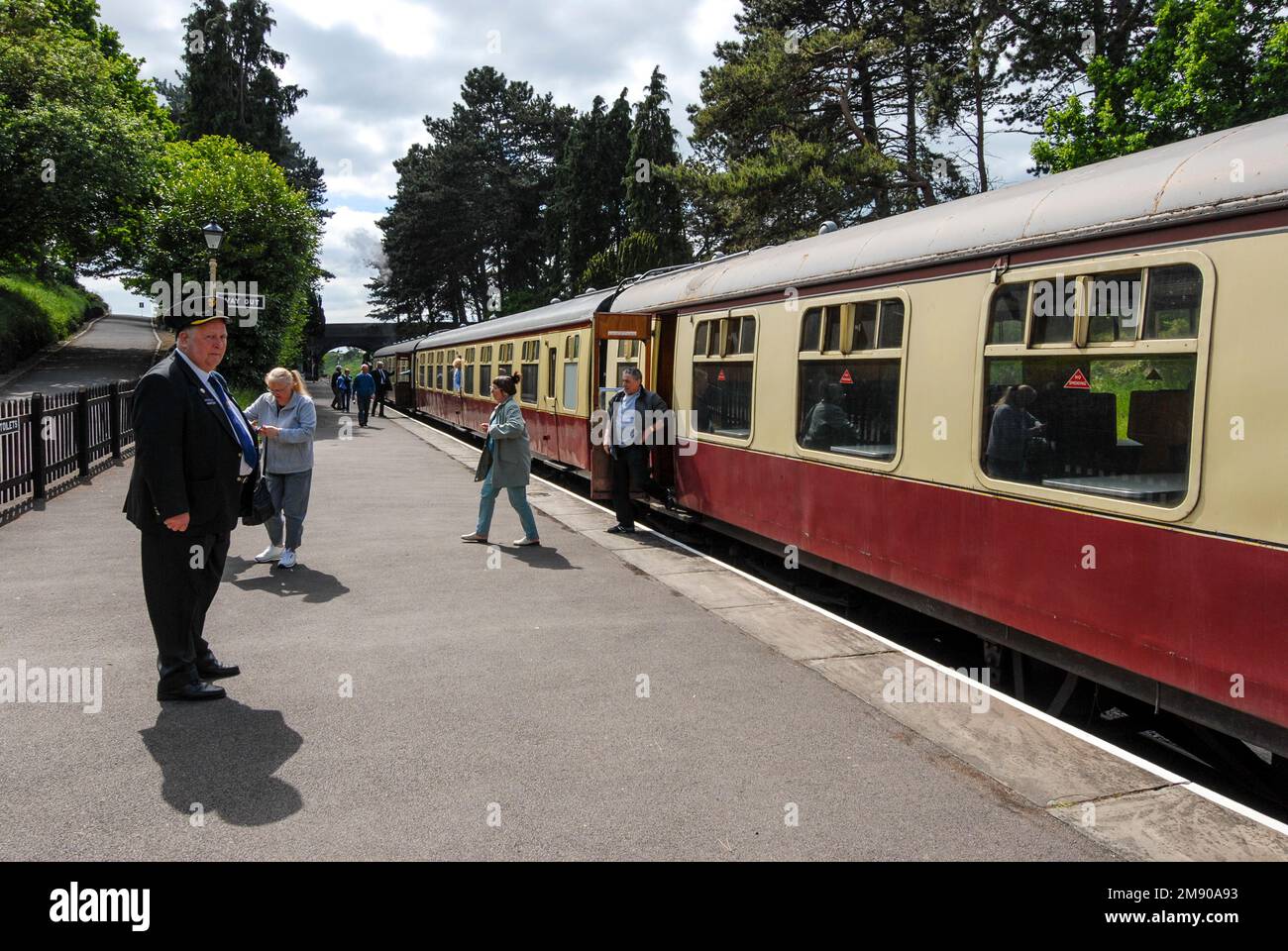 A train guard on the platform at t station in the Cotswolds, Britain. It is part of