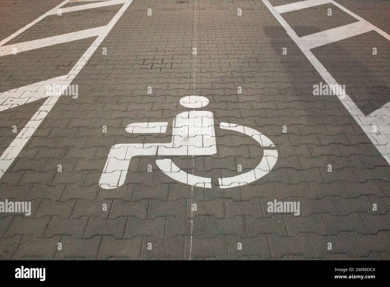 White sign of a parking lot for disabled people on a road Stock Photo