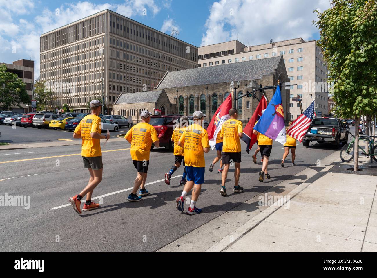 Men and women wearing bright yellow t-shirts in Run for the Fallen run in the streets of downtown Nashville, Tennessee. Stock Photo