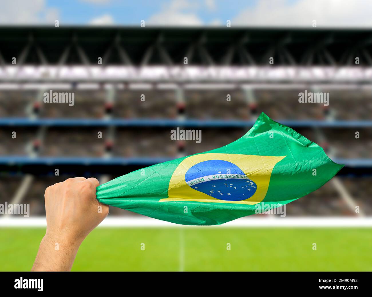 Brazilian fan holding the flag of Brazil at stadium.International soccer event and World Cup Stock Photo