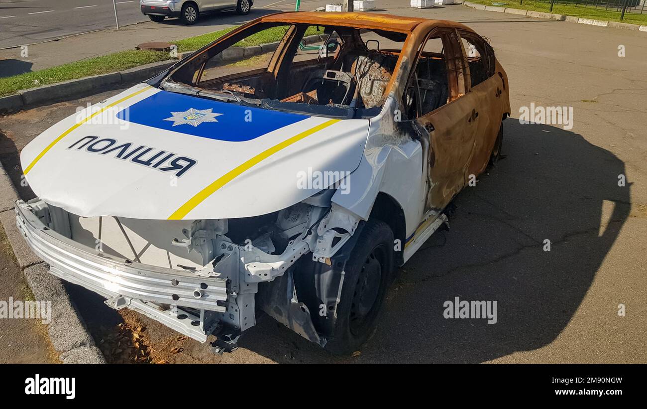 Burnt out police car. Vandalism, burned car. Car after the fire. Auto trash. Destroyed patrol car of the Ukrainian national police. Translation - Stock Photo