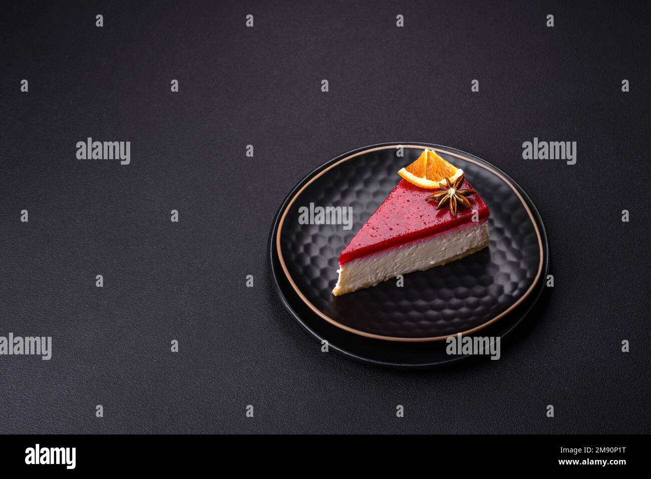 Delicious sweet cheesecake with raspberry jam on a black ceramic plate ...