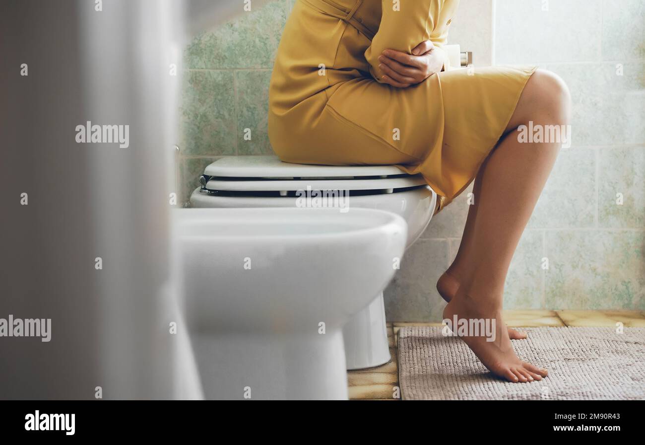 Unrecognizable woman on the toilet with stomach pain Stock Photo Alamy