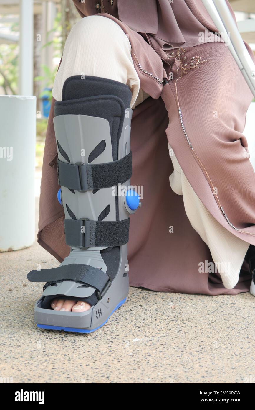 women broken feet with a grey plastic boot ankle brace injury protecting boot Stock Photo Alamy