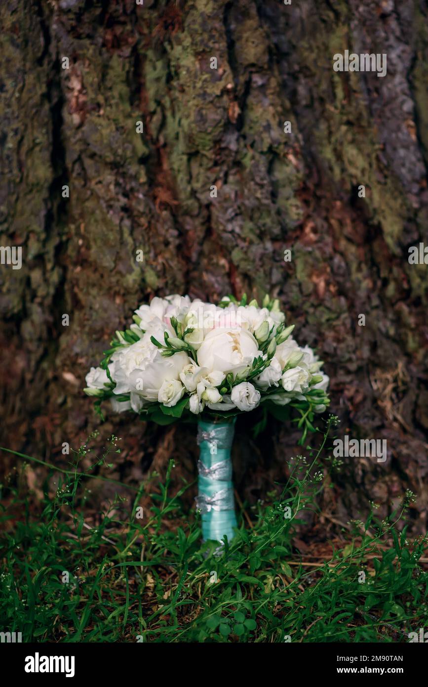 elegant wedding bouquet of white and pink peonies and roses lying on a ...