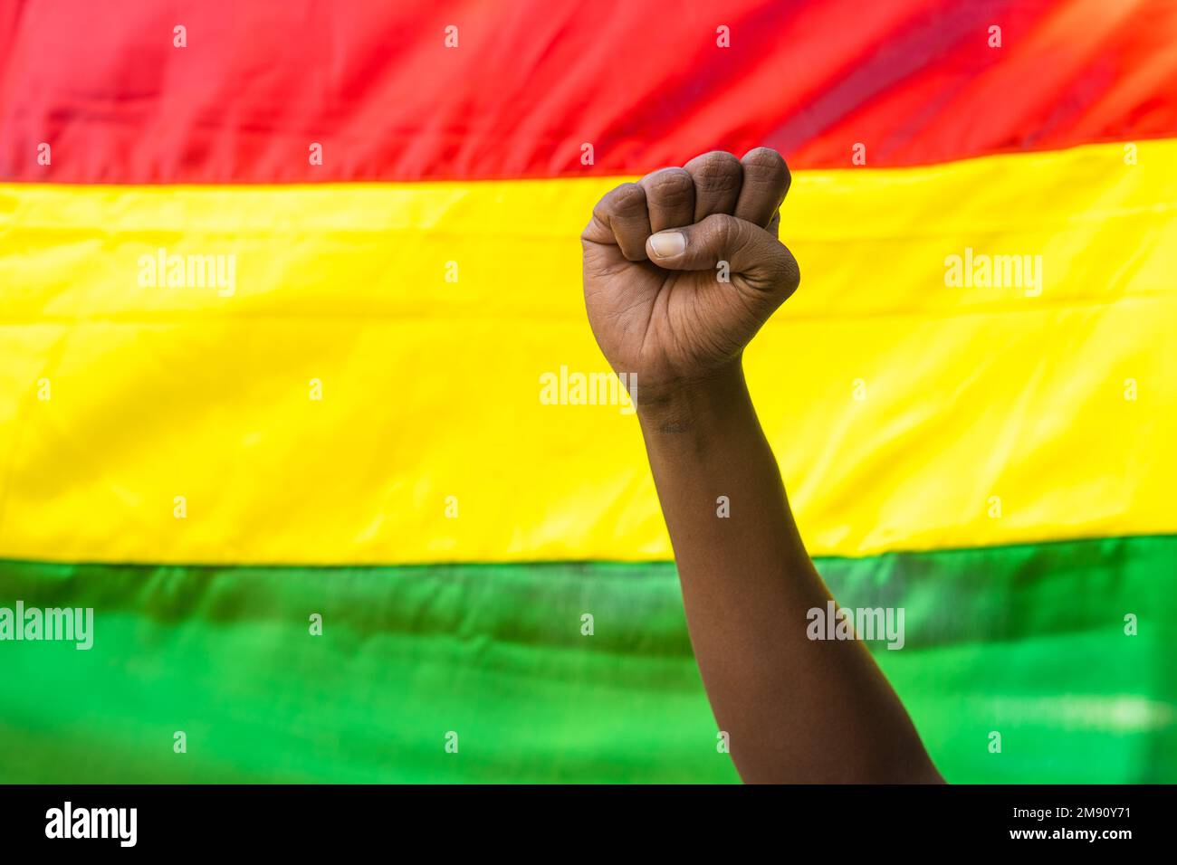 Concept of black history month celebration or activist Hand rising waving against flag. Stock Photo