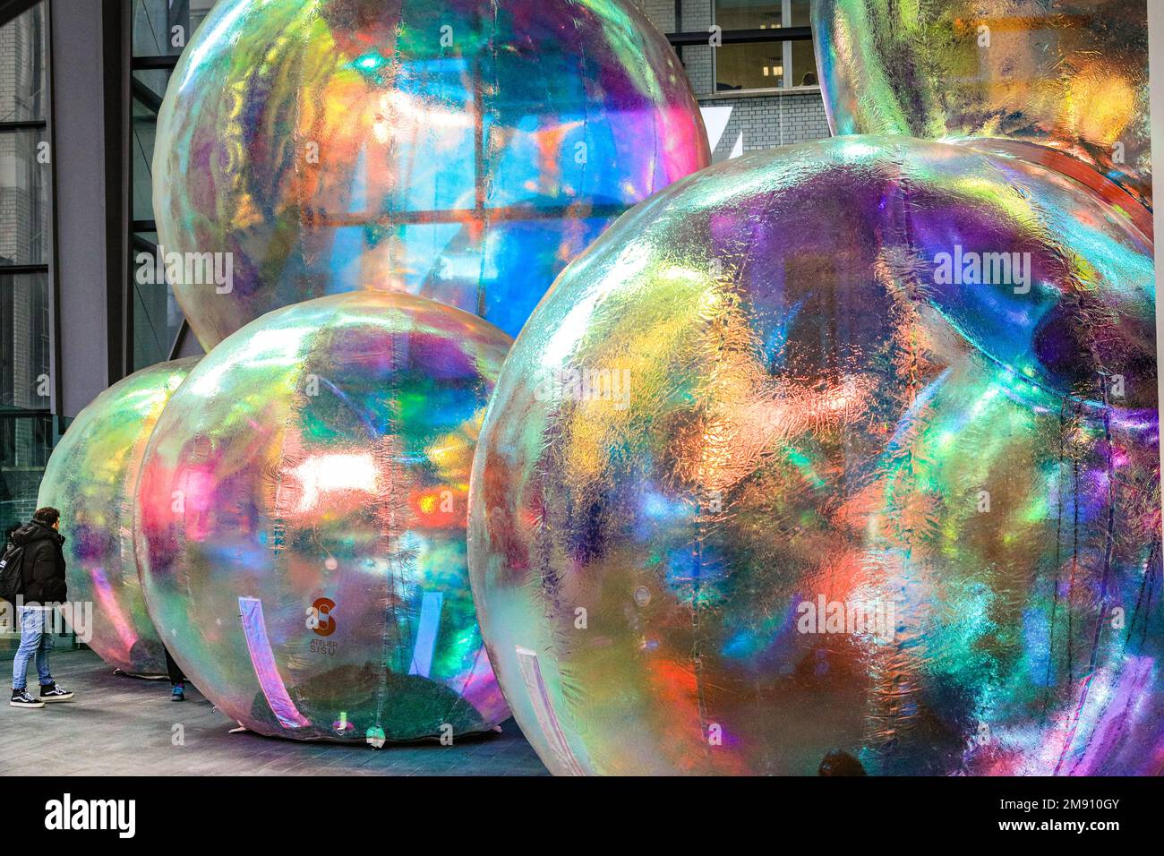 London, UK. 16th Jan, 2023. The public wander around the installation. New outdoor art installation 'Evanescent' by Atelier Sisu brings light to the City of London. The iridescent bubbles, which the public can walk under and around, are illuminated at night and are installed outside the iconic Leadenhall Building until the 10th of February. The installation, shown in London for the first time after its premiere in Australia. Evanescent by Atelier Sisu has been commissioned by ECBID and produced by Festival.org. Credit: Imageplotter/Alamy Live News Stock Photo