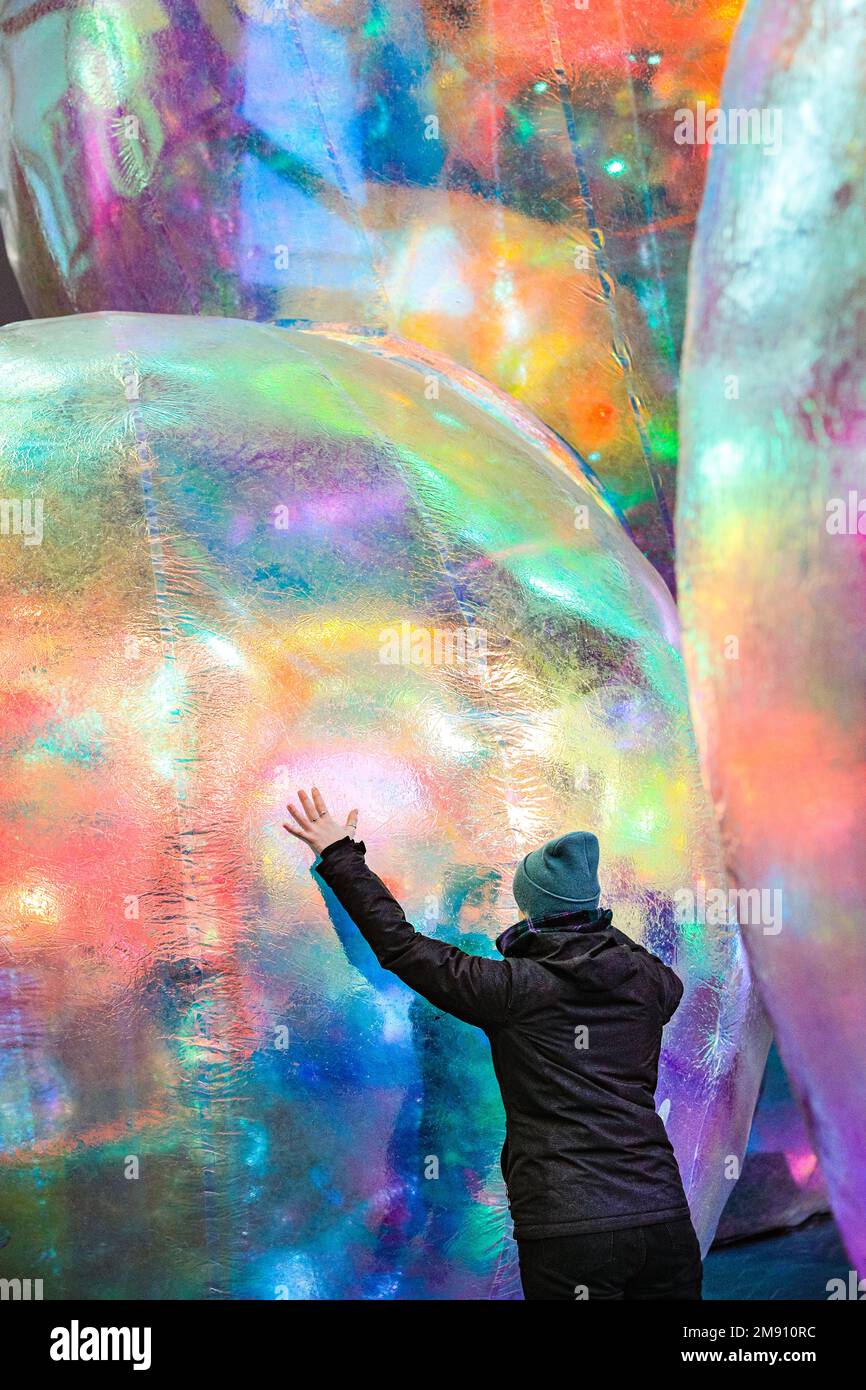 London, UK, 16th Jan 2023. A member of staff poses with the installation. New outdoor art installation 'Evanescent' created by Sydney-based Atelier Sisu, brings light to the City of London.The iridescent bubbles, which the public can walk under and around, are illuminated at night and are installed outside the iconic Leadenhall Building until the 10th of February. The installation, shown in London for the first time after its premiere in Australia, is delivered by FESTIVAL.ORG in collaboration with support from the City of London Corporation and Leadenhall Building. Stock Photo