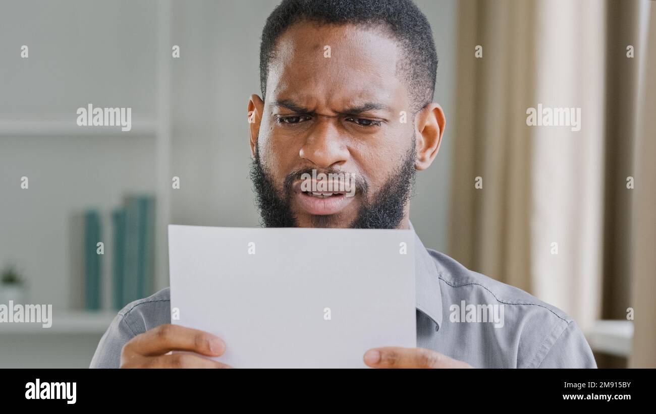 Unhappy African American bearded guy man received bad news reading
