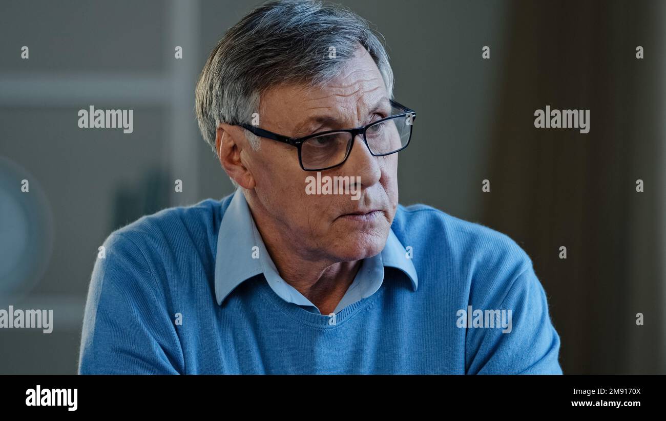 Close up old thoughtful pensive confused senior man feel worried think memory problem forgotten information, elderly old teacher look away anxious Stock Photo