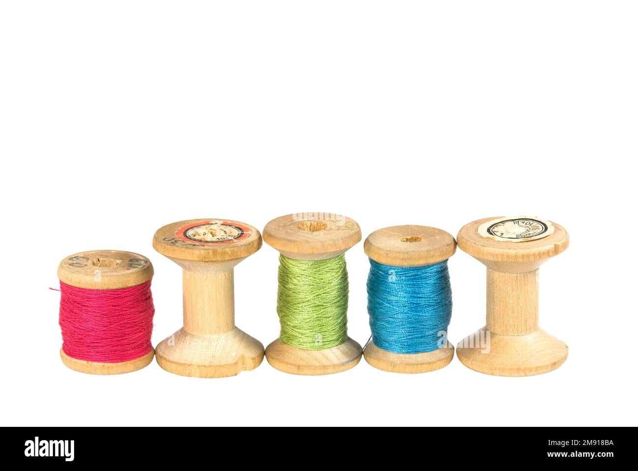 Old wooden reels of thread on white Stock Photo