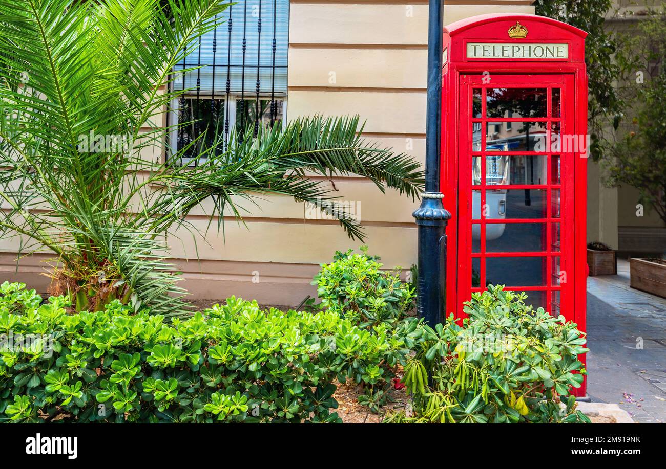 Cityscape with traditional British red telephone box on street of town. Gibraltar, Europe Stock Photo