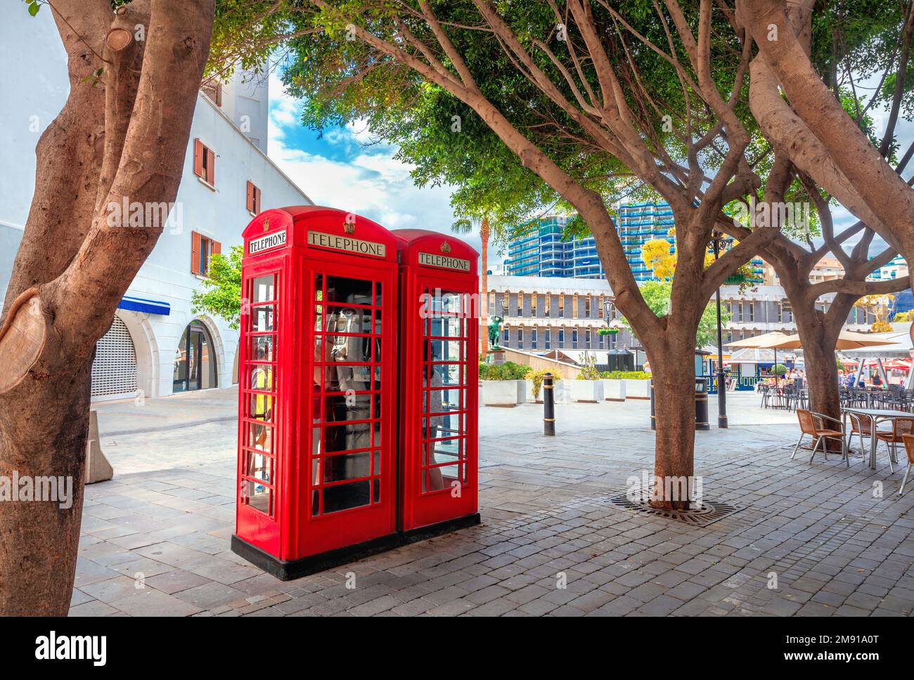 Cityscape with two English red telephone boxes on pedestrian main street at centre of town. Gibraltar, Europe Stock Photo