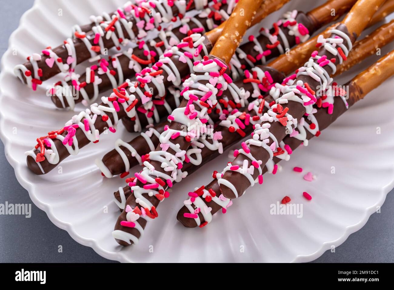 Valentines day treat, chocolate covered pretzel rods with sprinkles