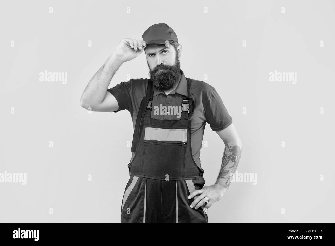 bearded man mechanic in work clothes on yellow background Stock Photo