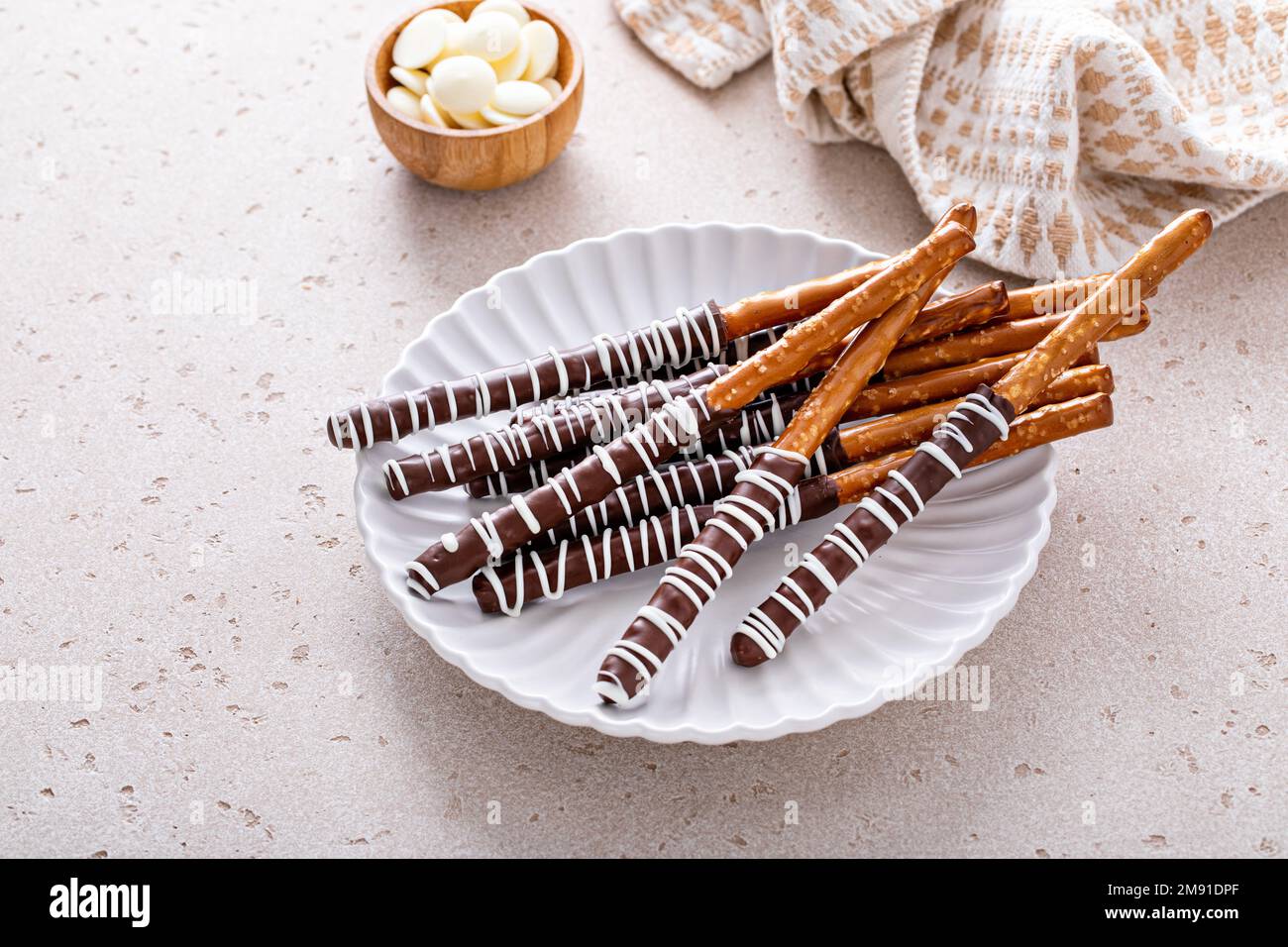 Chocolate covered pretzel rods homemade on a white plate Stock Photo Alamy