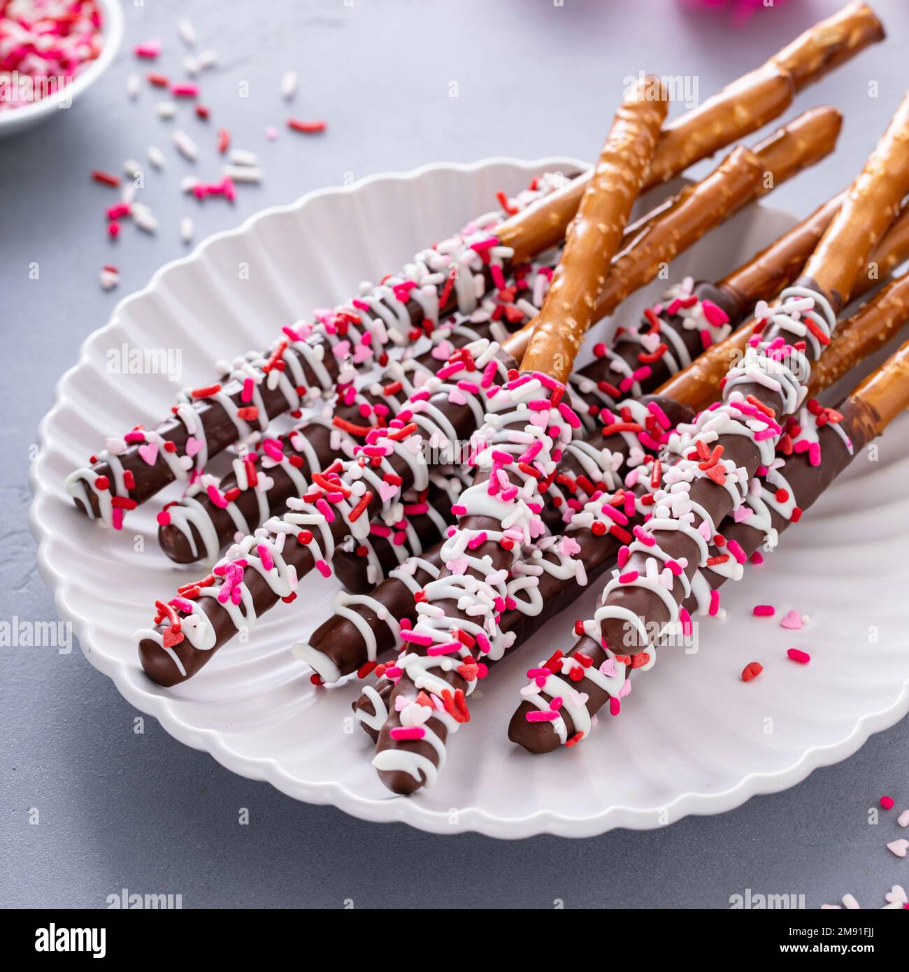 Valentines day treat, chocolate covered pretzel rods with sprinkles
