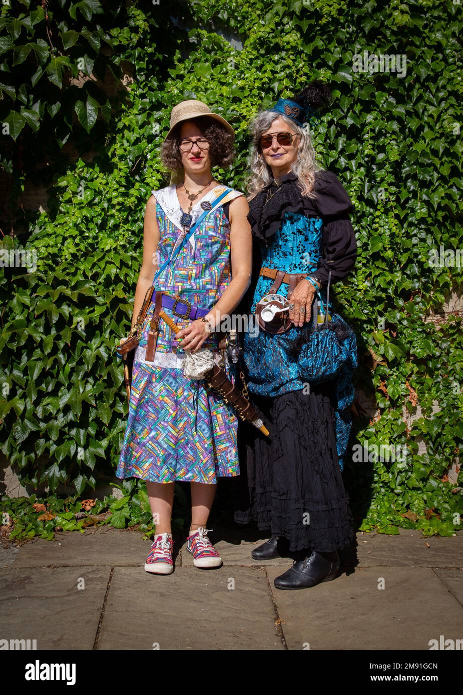Two female steampunks, one wearing a teacup holster. Explorer, traveller, adventurer themed steampunk costumes. Stock Photo