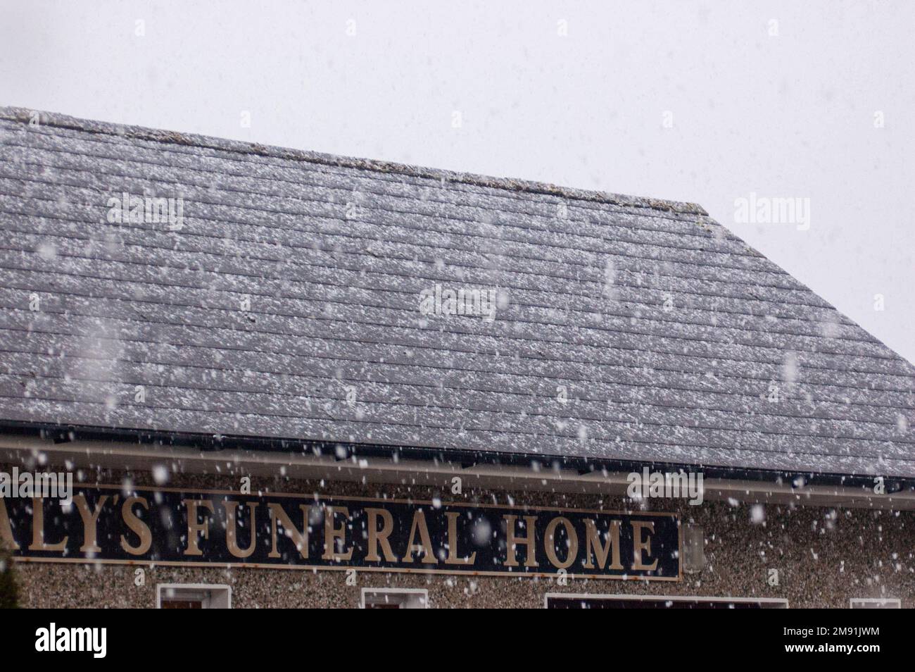 Drimoleague, West Cork, Ireland, Monday 16 Jan 2023; Light snow fell in Drimoleague today.  People where able to walk and drive with out any problems but it was welcomed. Snow falls on Daly's Funeral home on Chapel Street. Credit; ED/Alamy Live News Stock Photo