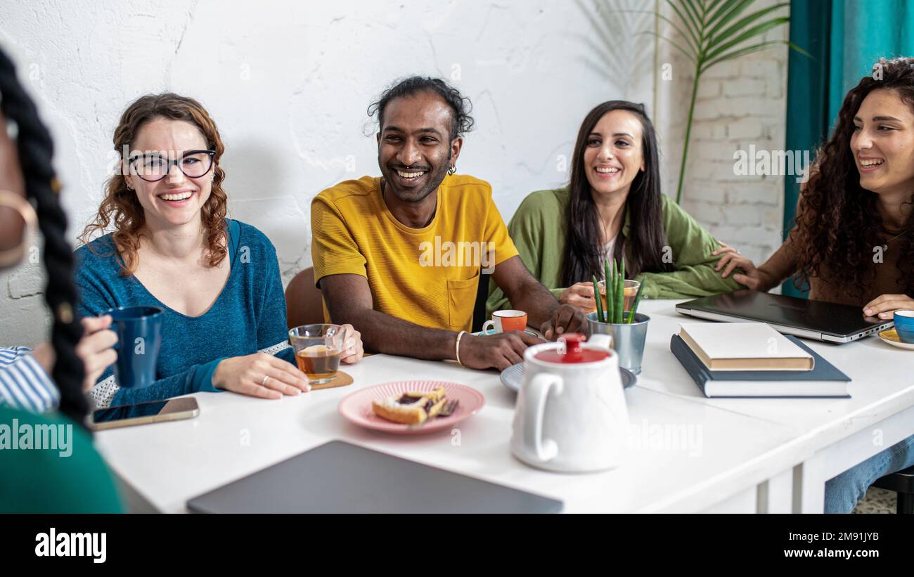 Young college students take a break in cafeteria to drink coffee and