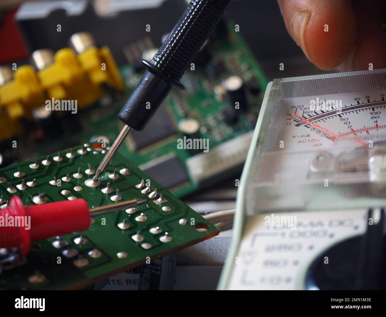Electronic circuit board testing or troubleshooting with a multimeter. Electronics industry background. Stock Photo
