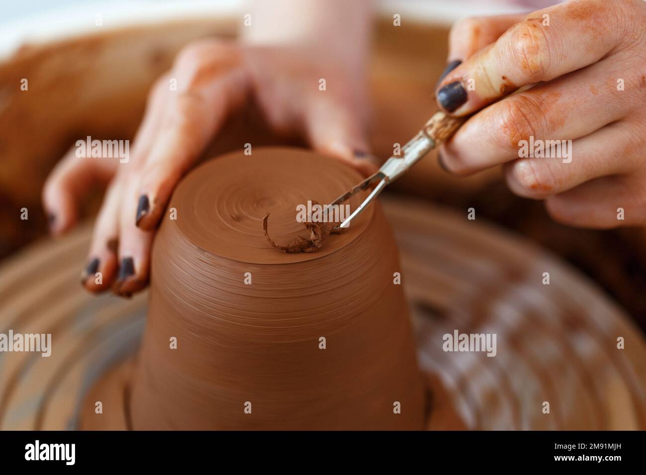 Female hands hold a bowl for casting clay products. Shaped method for making clay dishes. Handwork. Pottery making.Close up.pottery wheel Stock Photo