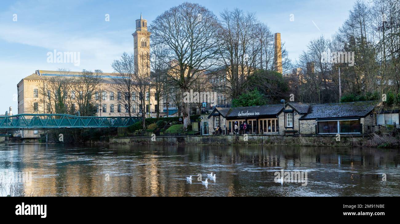 The River Aire at Saltaire, Yorkshire, England in winter. Salts Mill is in the background and the Boathouse Inn public house is on the riverside. Stock Photo